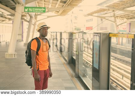 Young Black African Tourist Man Standing And Thinking While Waiting For The Train At Bts Sky Train S