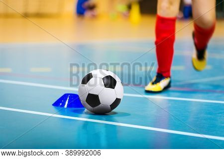 Football Futsal Ball, Wooden Floor, Training Marker And Running Player In Cleats. Indoor Soccer Spor
