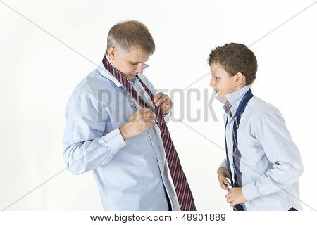 Father is showing his son how to tie a knot