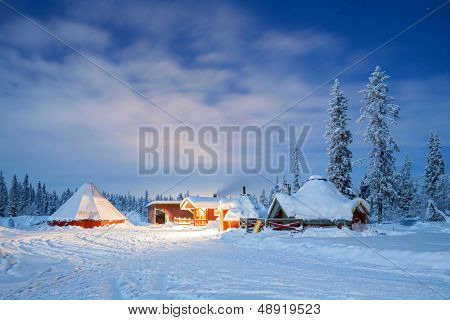 冬季景观与小屋小屋在晚上在基律纳瑞典拉普兰在晚上与明星足迹