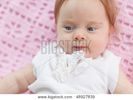 The Baby Lies On A Pink Towel. She's In Pink Shorts And A White Blouse.