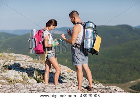 Hikers With Backpacks Enjoying Valley View From Top Of A Mountain