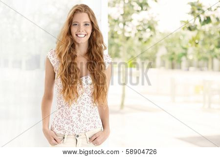 Summer portrait of long hair gingerish woman, smiling happy, looking at camera. Plenty of copyspace.