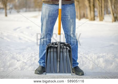 Man with a snow shovel on the trails