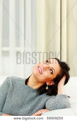 Portrait of a middle-aged smiling woman lookin up at home