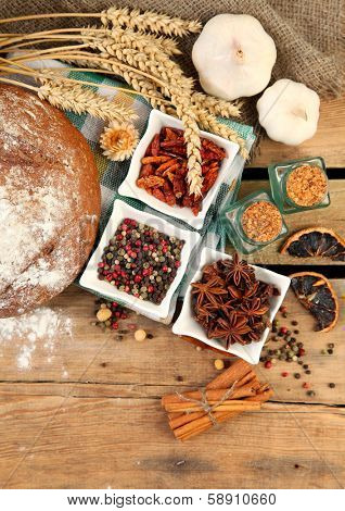 fresh bread and spices on wooden background