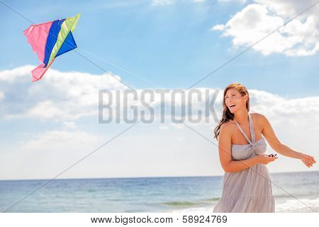 happy carefree female laughin on using kite