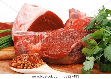raw meat : fresh beef pork big rib and fillet with garlic and green stuff on wood isolated over white background