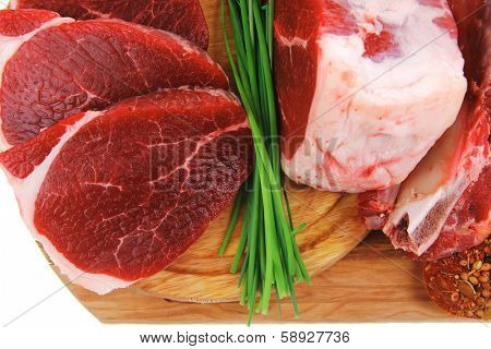 raw meat : fresh beef pork big rib and fillet with garlic and green stuff on wood isolated over white background