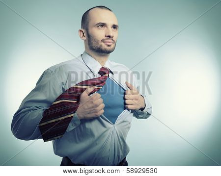 Super hero. Business manopening his shirt like a superhero, over blue background