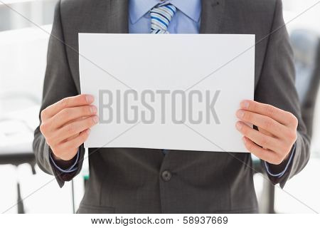 Businessman holding blank page in the office