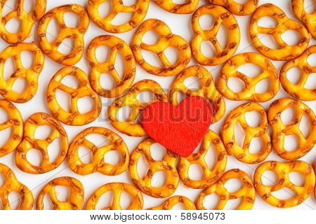 Valentine's Day Background Pretzels Pattern And Red Heart.