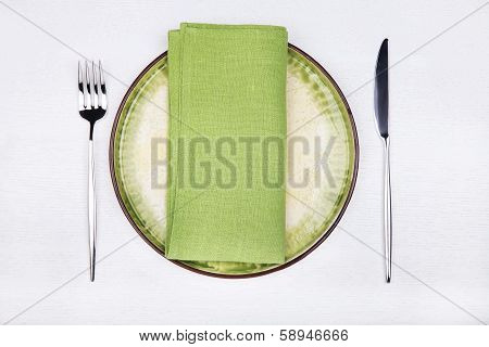 Serving - Fork, Knife And Green Napkin On Green Plate