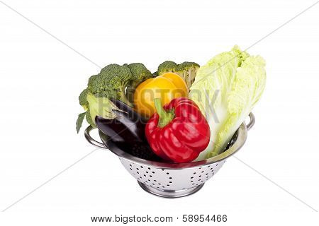 Fresh Vegetables In Metal Colander Over White