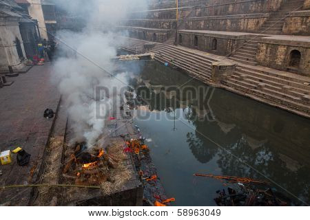 KATHMANDU, NEPAL - DEC 20: During the cremation ceremony along the holy Bagmati River in Bhasmeshvar Ghat at Pashupatinath temple, Dec 20, 2013 in Kathmandu, Nepal.