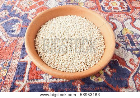 Cereal wheat in the bowl of clay over Armenian carpet