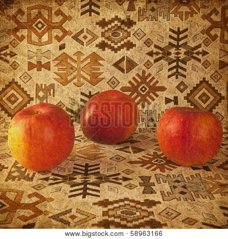 Apples on a carpet with ethnic ornaments