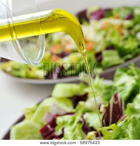 some plates with mesclun, a mix of assorted salad leaves, dressed with olive oil