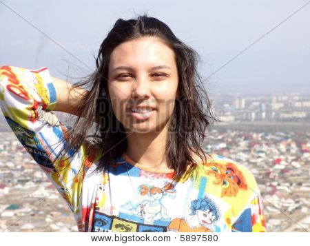 Le sourire de la fille au fond de la ville et le ciel de printemps