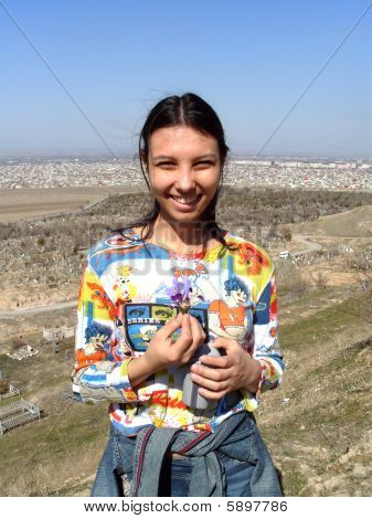 Rire fille tenant une fleur pourpre