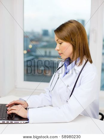 medicine and healthcare concept - busy doctor with laptop computer