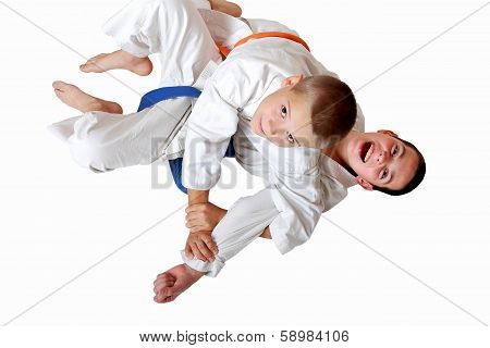 Athletes in a kimono with a blue and orange belt make the receipt of  capture hand