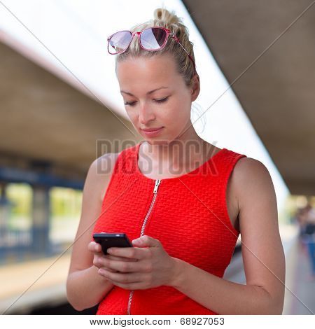 Young woman on platform of railway station.