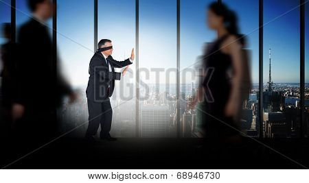 Mature businessman in a blindfold against room with large window looking on city