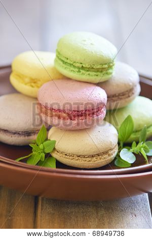 Colorful macaroons on brown plate