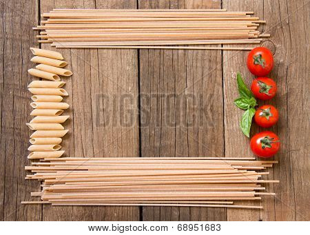 Pasta, Tomatoes And Basil On Wooden Background