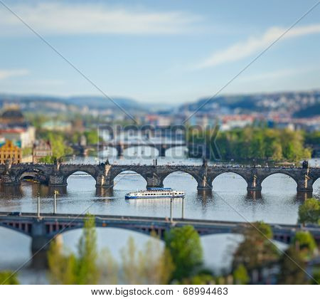 Travel Prague concept background - elevated view of bridges over Vltava river from Letna Park with tilt shift toy effect shallow depth of field. Prague, Czech Republic