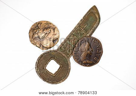 Three ancient bronze coins with portraits of emperors on a white background