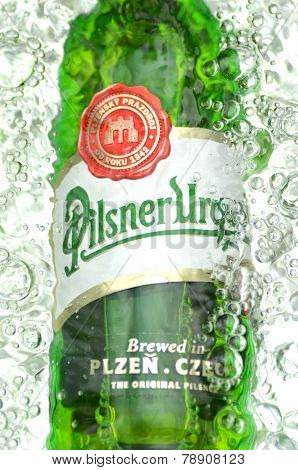 Pilsner Urquell pale lager beer in splashed water.
