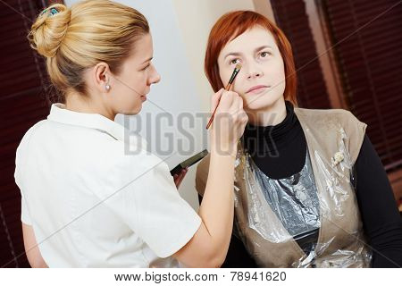 Makeup technique. Applying eye shadow on redheaded woman