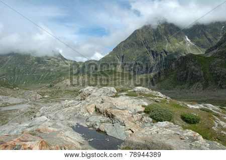 Rocks In Valley Nearby Glacier In Alps In Switzerland