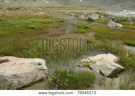 Rocks And Water In Valley Nearby Glacier In Alps In Switzerland