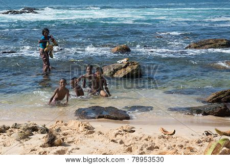 Happy Sinhalese Family Washing Coconuts