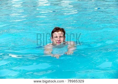 Boy Has Fun Swimming In The Pool