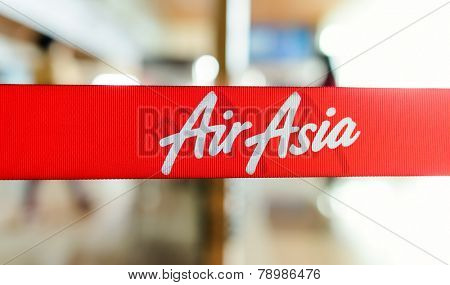 KUCHING - MAY 06: red tape with Airasia inscription on May 06, 2014 in Kuching, Malaysia. AirAsia Berhad is a Malaysian low-cost airline headquartered in Kuala Lumpur, Malaysia