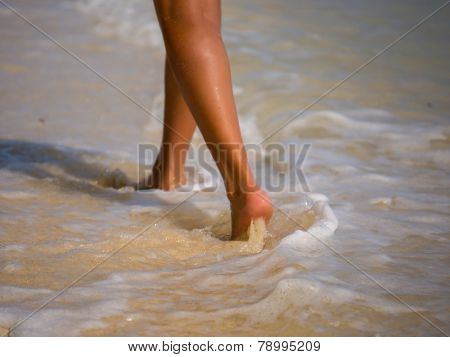 Woman walking on the sandy beach - Selective focus