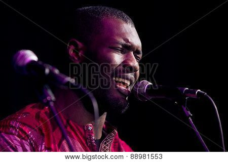 Black man singing and playing guitar