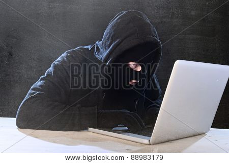 Hacker Man In Black Hood And Mask With Computer Laptop Hacking System In Digital Intruder Cyber Crim