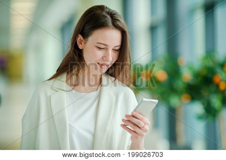 Young woman in international airport walking with her luggage.