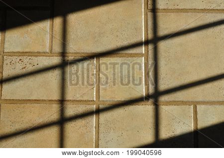 Shadow patterns on a ceramic and grout tile kitchen floor.