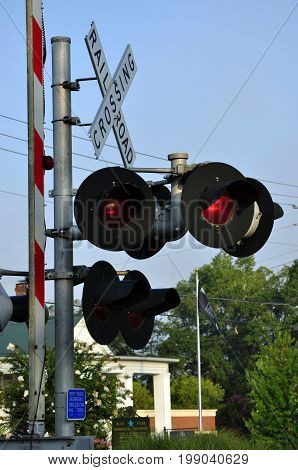 Railroad crossing signal standing sentinel at the intersection of a railroad track and state highway.