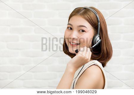 Casual Asian businesswoman wearing microphone headset as a telemarketing customer service agent call center job concept