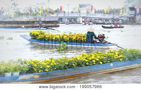 Soc Trang, Vietnam - January 21, 2017: Boats flower exchange trade on the river in the morning with the boat loaded with daisies which only sell flowers on Tet new floating market Soc Trang, Vietnam