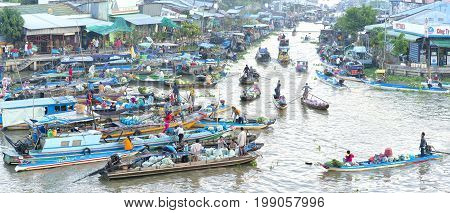 Soc Trang, Vietnam - January 21st, 2017: Farmers purchase crowded in floating market morning with dozens boats along river trade agricultural products serves traditional New Year in Soc Trang, Vietnam