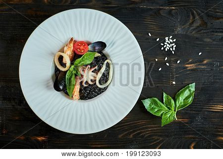 Dish of risotto with squid ink on grey plate