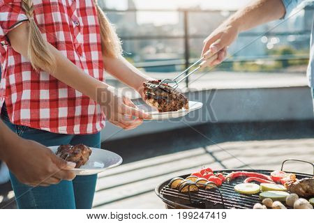 Group of people having barbecue party cooking meat